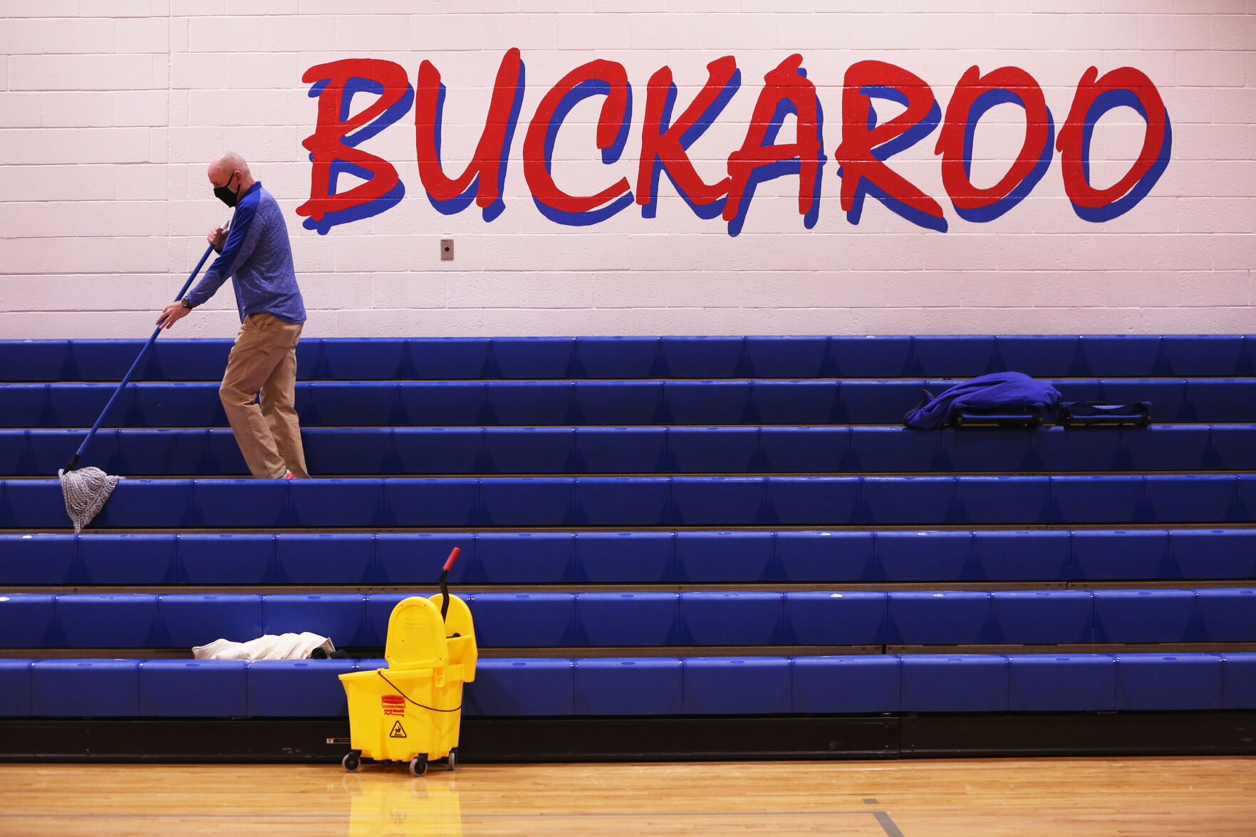 Jason Humble mops the seats of the bleachers
